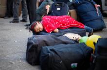 A Palestinian girl sleeps as she waits to cross the border into Egypt