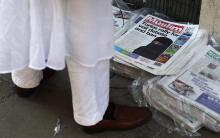A man looks at newspapers outside the Brick Lane Jamme Masjid (mosque) before Friday prayers in east London
