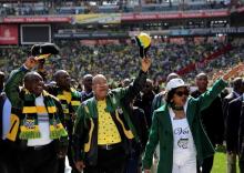 African National Congress (ANC) president Jacob Zuma (C) waves to his supporters next to his deputy, Cyril Ramaphosa (L) as they arrive for the parties traditional Siyanqoba rally, South Africa, July 31, 2016. PHOTO BY REUTERS/Siphiwe Sibeko