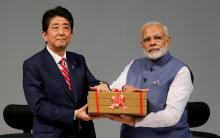 Japanese Prime Minister Shinzo Abe (L) and his Indian counterpart Narendra Modi hold a replica of a brick during the India-Japan Annual Summit, in Gandhinagar, India, September 14, 2017. PHOTO BY REUTERS/Amit Dave
