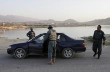 Afghan policemen search a car at a check point in Kabul