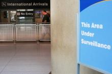 A sign warns of surveillance at the International Arrival area at Logan Airport in Boston. PHOTO BY REUTERS/Brian Snyder