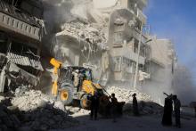 A front loader removes debris in a damaged site after airstrikes on the rebel held Tariq al-Bab neighbourhood of Aleppo, Syria, September 24, 2016. PHOTO BY REUTERS/Abdalrhman Ismail