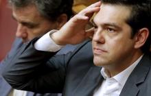 Greek Prime Minister Alexis Tsipras (R) reacts as he sits next to Finance Minister Euclid Tsakalotos during a parliamentary session in Athens, Greece, July 16, 2015. PHOTO BY REUTERS/Christian Hartmann