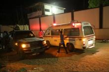 A man walks past an ambulance and armed security forces at the scene of an attack outside an hotel in Mogadishu, Somalia, June 14, 2017. PHOTO BY REUTERS/Stringer