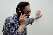 Malaysian politician Anwar Ibrahim takes a phone call during during an interview with Reuters at his house in Kuala Lumpur, Malaysia, May 17, 2018. PHOTO BY REUTERS/Stringer