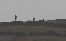Armed men, presumed by local sources to be Islamic State fighters, are pictured at a checkpoint in the west of Syrian town of Kobani, seen from near the Mursitpinar border crossing on the Turkish-Syrian border in the southeastern town of Suruc in Sanliurfa province