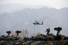 A U.S. Army's AH-64 Apache helicopter flies over amoured vehicles, during a U.S.-South Korea joint live-fire military exercise, at a training field, near the demilitarized zone, separating the two Koreas in Pocheon, South Korea, April 21, 2017. PHOTO BY REUTERS/Kim Hong-Ji