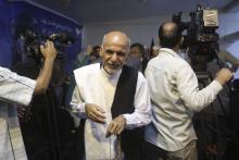 Afghan presidential candidate Ashraf Ghani Ahmadzai (C) leaves after a news conference in Kabul