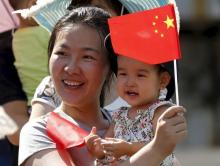 A woman and her baby wait on the street for a military parade marking the 70th anniversary of the end of World War Two, in Beijing, China, September 3, 2015. PHOTO BY REUTERS/Kim Kyung-Hoon