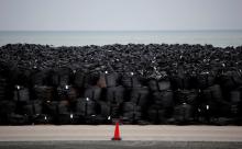 Big black plastic bags containing radiated soil, leaves and debris from the decontamination operation are dumped at a seaside, devastated by the March 11, 2011 earthquake and tsunami in Tomioka town, Fukushima prefecture, February 22, 2015. PHOTO BY REUTERS/Toru Hanai