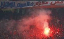Egyptian soccer fans known as "Ultras" shout slogans against the government and police while holding a flare during the African Nations Cup qualifying soccer match between Egypt and Botswana, in Cairo October 15, 2014. The banner reads, "Ultras not a criminal, Freedom for fans"