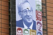 A bird flies past a banner, showing an image of the European Commission's new President Jean-Claude Juncker, on the facade of the European Commission headquarters in Brussels, November 4, 2014. PHOTO BY REUTERS/Francois Lenoir