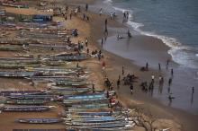 People are pictured on a beach next to fishing canoes in Dakar, Senegal, June 21, 2013. PHOTO BY REUTERS/Joe Penney