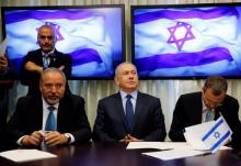 Avigdor Lieberman, head of far-right Yisrael Beitenu party, (L) sits next to Israeli Prime Minister Benjamin Netanyahu (C) as they sign a coalition deal to broaden the government's parliamentary majority, at the Knesset, the Israeli parliament in Jerusalem, May 25, 2016. PHOTO BY REUTERS/Ammar Awad