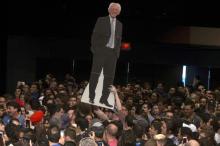 A man walks though a crowd of supporters with a cut-out depicting Bernie Sanders before a campaign event in Miami, March 8, 2016. PHOTO BY REUTERS/Carlo Allegri