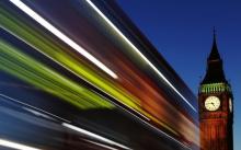 Light trails shine from a passing bus in front of Big Ben and the Houses of Parliament in London