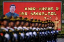 A picture of Chinese President Xi Jinping is on a billboard behind soldiers of China's People's Liberation Army marching during a training session for a military parade to mark the 70th anniversary of the end of World War Two, at a military base in Beijing, China, August 22, 2015. PHOTO BY REUTERS/Damir Sagolj