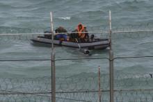 Moroccan soldiers on a boat attempt to board a would be migrant on Moroccan waters near the border fence that separates Spain's North African enclave of Ceuta from neighboring Morocco, March 2, 2014. PHOTO BY REUTERS/Juan Medina