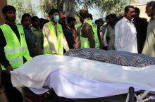 Men gather as rescue workers move the bodies of victims, who were killed in a Sufi shrine, on the outskirts of Sargodha, Pakistan, April 2, 2017. PHOTO BY REUTERS/Stringer
