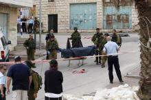 Israeli soldiers carry the dead body of one of two Palestinians, whom the Israeli military said were shot dead by Israeli troops after they attacked an Israeli soldier, in Tal Rumaida in the West Bank city of Hebron March 24, 2016. PHOTO BY REUTERS/Mussa Qawasma