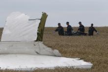 Members of the Ukrainian Emergency Ministry carry a body at the crash site of Malaysia Airlines Flight MH17, near the settlement of Grabovo in the Donetsk region