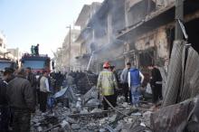 Civil Defence members work at the site of two bomb explosions in the Syrian city of Homs, Syria, in this handout picture provided by SANA, December 28, 2015. PHOTO BY REUTERS/SANA