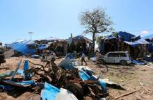 Somali policemen walk near a the wreckages of a destroyed cars at the scene of an explosion at a police checkpoint near the vegetable market in Waberi district of Somali capital Mogadishu, November 26, 2016. PHOTO BY REUTERS/Feisal Omar