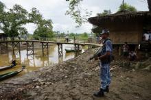A Myanmar border guard police officer stands guard in Taung Bazar village, Buthidaung township, northern Rakhine state, Myanmar, July 13, 2017. PHOTO BY REUTERS/Simon Lewis
