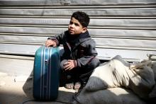A boy holds a suitcase during evacuation from the besieged town of Douma, Eastern Ghouta, in Damascus, Syria, March 13, 2018. PHOTO BY REUTERS/Bassam Khabieh