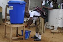 A boy washes his hands before going to school in Monrovia, February 16, 2015. PHOTO BY REUTERS/James Giahyue