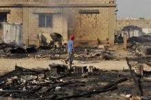 A boy walks near the remains of tents that were burnt in a refugee camp for Syrian refugees in Lebanon's Bekaa Valley, June 1, 2015. PHOTO BY REUTERS/Hassan Abdallah