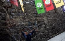 A boy carries a wheel as he walks past election banners of the pro-Kurdish Peoples' Democratic Party (HDP) in Diyarbakir, Turkey, October 31, 2015. PHOTO BY REUTERS/Stoyan Nenov