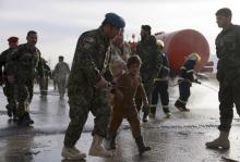 An Afghan National Army officer escorts a slightly injured boy from the site of a suicide attack on the outskirts of Mazar-i-Sharif, Afghanistan, February 8, 2016. PHOTO BY REUTERS/Anil Usyan