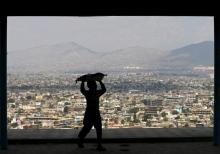 A boy carries bread on his head to sell on a hilltop overlooking Kabul, April 20, 2015. PHOTO BY REUTERS/Mohammad Ismail