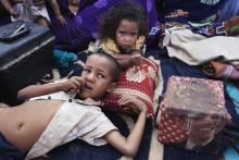 Elah, 7, (L) and Tahye Iselkou, 5, lie next to a box draped with a picture of U.S. President Barack Obama on the floor of their shelter at Mbera refugee camp in southern Mauritania, May 24, 2012. PHOTO BY REUTERS/Joe Penney