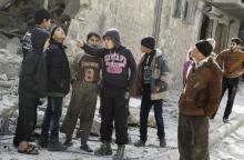 A boy gestures as others inspect the damage after airstrikes by pro-Syrian government forces in the rebel held al-Sakhour neighbourhood of Aleppo, Syria February 5, 2016. PHOTO BY REUTERS/Abdalrhman Ismail