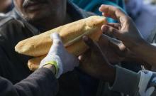Migrants receive bread in a makeshift camp outside the foreign office in Brussels, Belgium, September 14, 2015. PHOTO BY REUTERS/Yves Herman