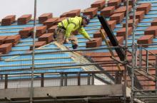 A builder works on the roof of a new residential property development in north London, March 21, 2013. PHOTO BY REUTERS/Neil Hall