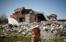 An Iraqi boy walks past a building destroyed during the fighting between Iraqi forces and Islamic states militants in Qayyara, Iraq, April 6, 2017. PHOTO BY REUTERS/Suhaib Salem
