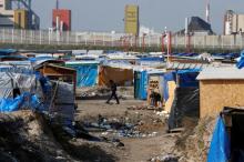 A migrant walks past makeshift shelters in the northern area on the final day of the dismantlement of the southern part of the camp called the 'Jungle" in Calais, France, March 16, 2016. PHOTO BY REUTERS/Pascal Rossignol