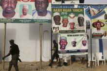 Policemen walk in front of posters of candidates of Nigeria's President Goodluck Jonathan People's Democratic Party in Kano, March 26, 2015. PHOTO BY REUTERS/Goran Tomasevic