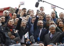 Can Dundar, editor-in-chief of Cumhuriyet, (centre L) and his Ankara bureau chief Erdem Gul greet their supporters as they arrive at the Justice Palace in Istanbul, Turkey, March 25, 2016. PHOTO BY REUTERS/Osman Orsal