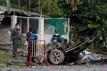 Police forensic unit members examine the site of a roadside bomb blast in the southern province of Pattani, Thailand, August 17, 2017. PHOTO BY REUTERS/Surapan Boonthanom