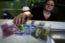 A cashier displays Swiss bank notes at a currency exchange office in Warsaw, January 16, 2015. PHOTO BY REUTERS/Adam Stepien