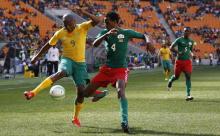 South Africa's Lebogang Manyama (L) is challenged by Burkina Faso's Daila Pierre during the inaugural Nelson Mandela Sport and Culture Day at the soccer city stadium in Soweto