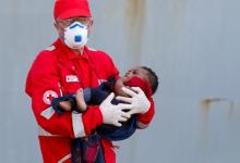 A member of the Italian Red Cross holds a child after disembarking from the Italian Navy vessel Aviere in the Sicilian harbour of Augusta, Italy, June 10, 2016. PHOTO BY REUTERS/Antonio Parrinello