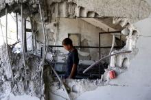A child inspects a site hit by what activists said was an airstrike by forces loyal to Syria's President Bashar el-Asaad at Arbin town in Damascus countryside, Syria, July 21, 2015. PHOTO BY REUTERS/Bassam Khabieh