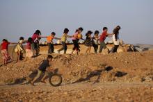 Children, who are internally displaced due to the fighting between rebels and the forces of Syrian President Bashar al-Assad, play inside Al-Tah camp in the southern Idlib countryside