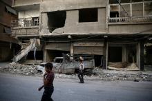 Children walk near damaged buildings in rebel-held Ain Tarma, eastern Damascus suburb of Ghouta, Syria September 17, 2016. PHOTO BY REUTERS/Bassam Khabieh